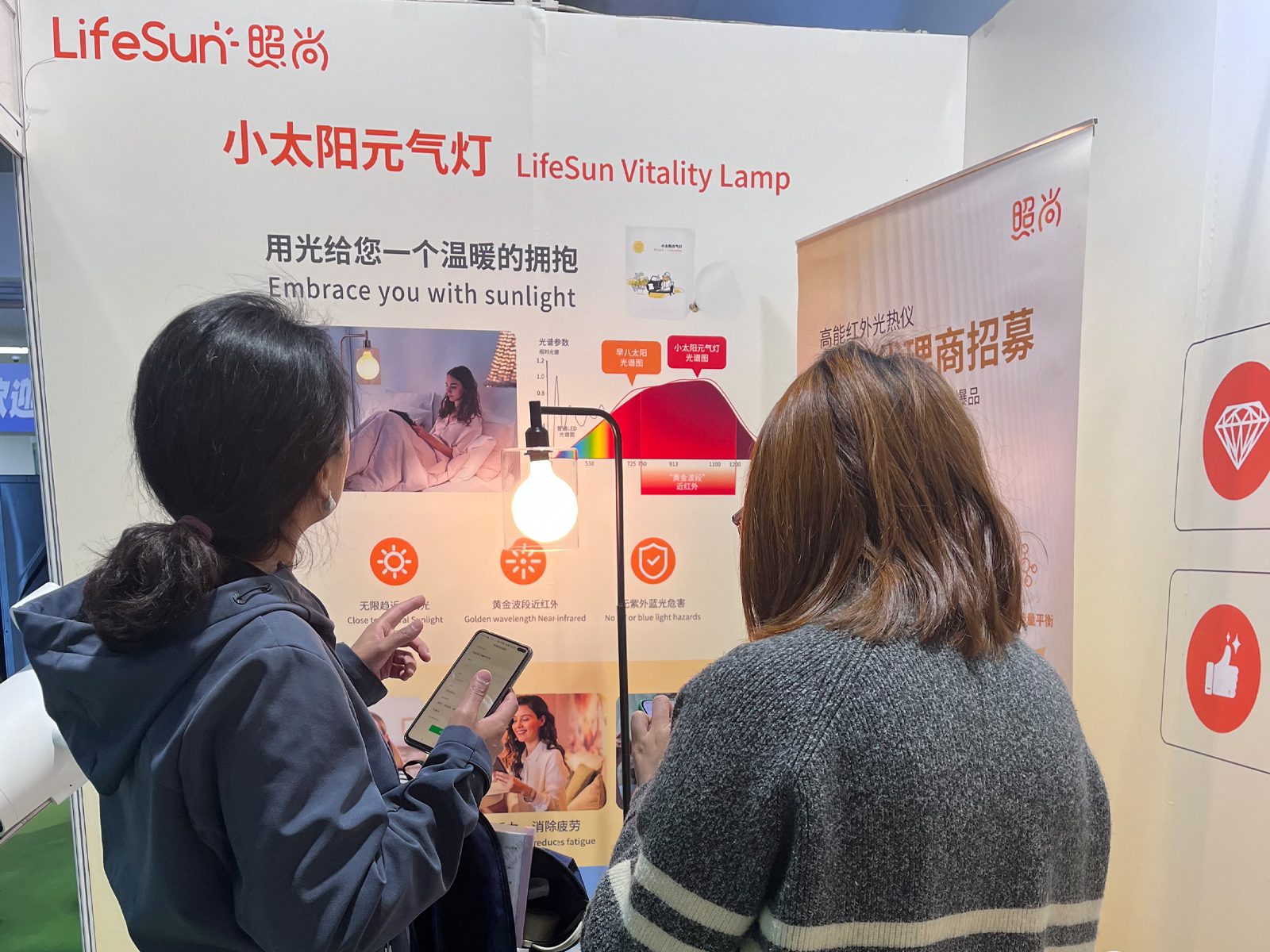 客户在照尚健博会展位咨询小太阳元气灯 客户在照尚健博会展位咨询小太阳元气灯